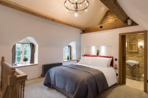 a bedroom with a king sized bed and a bathroom at The Royal Oak Tetbury in Tetbury