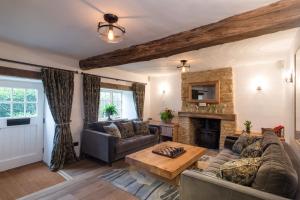 The Royal Oak Tetbury في تيتبري: غرفة معيشة مع أريكة ومدفأة