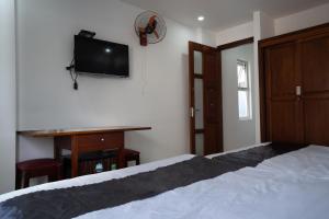 um quarto com uma cama, uma secretária e uma televisão em Hotel Hoàng Thịnh em Da Nang