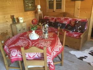 una mesa con un mantel rojo y un sofá en Chalet pour 2 amoureux, en Allinges