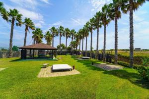 un parc avec des palmiers et un kiosque dans l'établissement Amareclub Baia Dei Turchi Resort - Adults Only, à Otrante