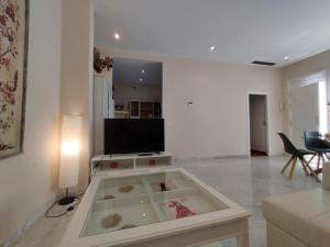 a living room with a tv and a table at Alleanza, Suite Cathedral, Private Rooftop in Seville +48 photos