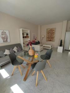 sala de estar con mesa de cristal y sillas en Suite Apartament Cathedral en Sevilla