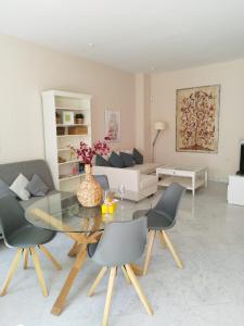 a living room with a glass table and chairs at Suite Apartament Cathedral in Seville