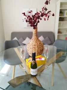 a glass table with a bottle of wine and two glasses at Alleanza, Suite Cathedral, Private Rooftop in Seville
