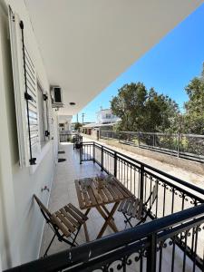 balcone con tavolo e sedie. di Porfyra Apartment Portoheli a Porto Heli