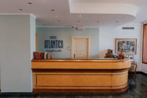 una sala de justicia con un banco de madera en una sala en Hotel Atlantico, en Castiglioncello