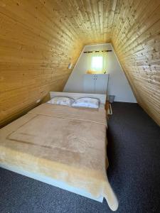 Ce lit se trouve dans une petite chambre dotée d'un plafond en bois. dans l'établissement MELA, à Materija