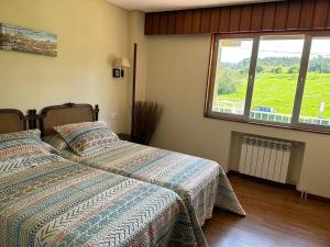 a bedroom with two beds and a large window at Villa Amelia in Llanes