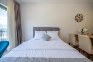 a bedroom with a bed and a desk and a clock at Andjela's Studio in Kotor +14 photos