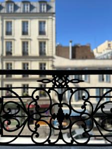 um corrimão preto com um edifício ao fundo em Champs Elysées area - Deluxe Family Apartments em Paris