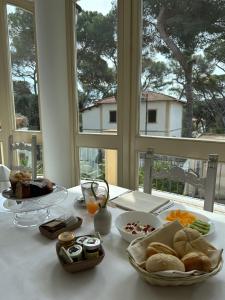 une table avec des assiettes de nourriture sur une table avec une fenêtre dans l'établissement Hotel Atlantico, à Castiglioncello
