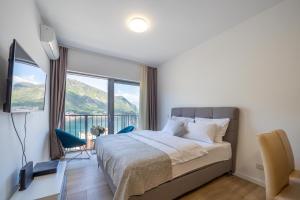 a bedroom with a bed and a large window at Andjela's Studio in Kotor