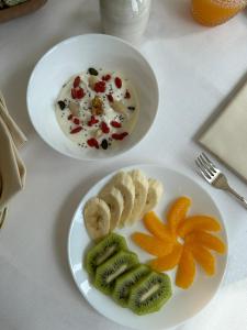 two plates of food with fruit on a table at Hotel Atlantico in Castiglioncello