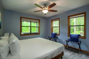 a bedroom with a bed with a ceiling fan and two chairs at Coyote Crossing Hot Tub Arcade Games in Pigeon Forge