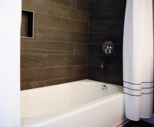 uma casa de banho com uma banheira branca e uma cortina de chuveiro. em Omaha Marriott em Omaha