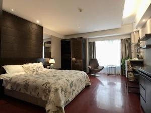 a bedroom with a large bed and a desk at Nanjing Kaibin Apartment - Aishang Shopping Mall in Nanjing