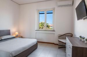 a bedroom with a bed and a window at Ortensia Apartments by Wonderful Italy in Aci Castello