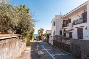 a street with houses and the ocean in the background at Ortensia Apartments by Wonderful Italy in Aci Castello