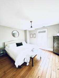 Un dormitorio con una gran cama blanca y una mesa en The Farmhouse at Glenwood Retreats, 