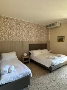 two beds sitting next to each other in a room at Hotel Atlantico in Castiglioncello