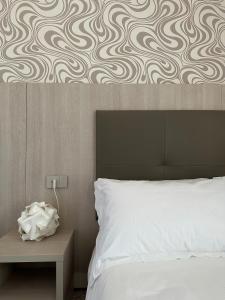 a bedroom with a bed and a wall with a pattern at Hotel Atlantico in Castiglioncello