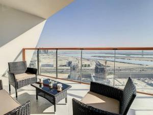 a balcony with chairs and a table and a view of an airport at Key View - Binghatti Avenue, Al Jaddaf in Dubai