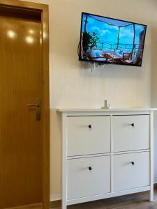 a white dresser with a flat screen tv on a wall at Zio Nino in Sutomišćica