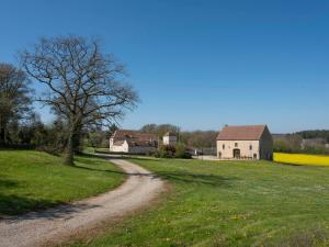 a dirt road next to a field and a barn at Viola in Asquins