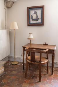 a wooden desk with a chair and a lamp at Viola in Asquins