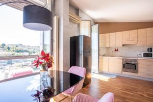 una cucina con tavolo, sedie rosa e frigorifero di Stazione Tribunale & Università Bright Apartment a Pescara