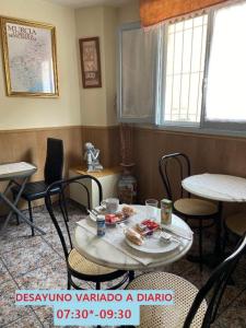 une salle avec des tables, des chaises et une table avec de la nourriture. dans l'établissement Hotel Arce, à San Pedro del Pinatar