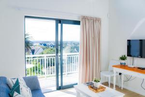 a living room with a large window with a balcony at Cottage with a View in St Francis Bay