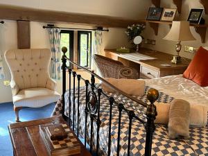 a bedroom with a bed and a desk and a chair at Paul's Farmhouse in Hawkhurst