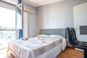 una camera da letto con un letto, un tavolo e una finestra di Stazione Tribunale & Università Bright Apartment a Pescara