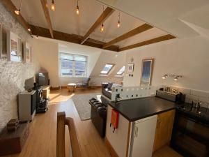 a living room with a kitchen and a living room with a couch at Tighnabruaich Duplex Apartment - Sea Views in Tighnabruaich