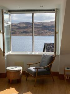 una silla en una habitación con una ventana grande en Tighnabruaich Duplex Apartment - Sea Views, en Tighnabruaich