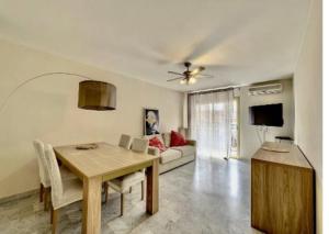 uma sala de estar com uma mesa e um sofá em Mimosas -2 rooms-Terrace-City center -Air conditioning em Cannes