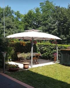 biały parasol na dziedzińcu ze stołem w obiekcie Holiday-Home-Desenzano w mieście Desenzano del Garda
