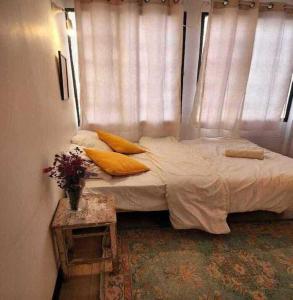 a bed with pillows and a table in a room at Jaffa Seaside House in Tel Aviv