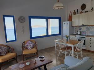 a kitchen and living room with a table and chairs at Sunset Holiday House in Archangelos