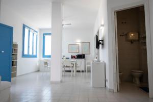 Habitación blanca con mesa y comedor en Casa Blu sul mare e centralissima, en San Vito lo Capo
