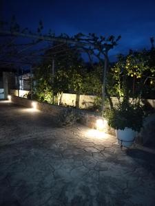 un giardino notturno con luci su un patio di Litsa's House Platanias ad Agia Paraskevi