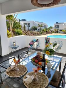 a table with fruit and wine on a balcony with a pool at Casilla de Costa in Villaverde