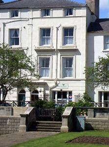 a large white building with stairs in front of it at Admiral Guest House in Scarborough