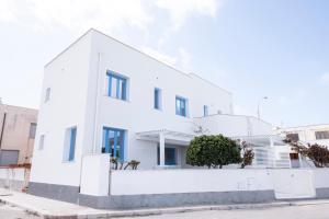 a white house on a street at Casa Blu sul mare e centralissima in San Vito lo Capo