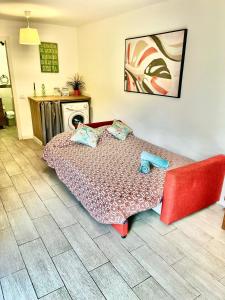 una camera con un letto e un divano rosso di Cozy apartment in centric area at caleta de fuste with Air Conditioner a Caleta De Fuste
