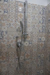 a shower in a bathroom with tiles on the wall at B&B porta Garibaldi in Catania