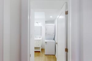 a white bathroom with a sink and a mirror at The Cottages at Blue in Blue Mountains