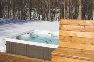 a jacuzzi tub in the snow on a deck at The Cottages at Blue in Blue Mountains